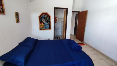 a bedroom with a blue bed in a room at Maré Alta Hostel in Ubatuba