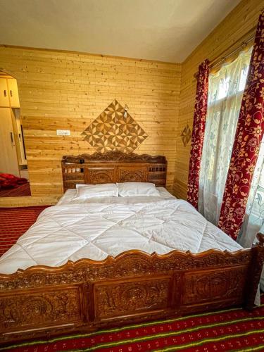 a large wooden bed in a room with at Nature's Resort in Srinagar