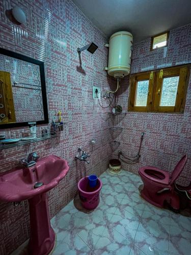 y baño con lavabo rosa y aseo. en Nature's Resort, en Srinagar