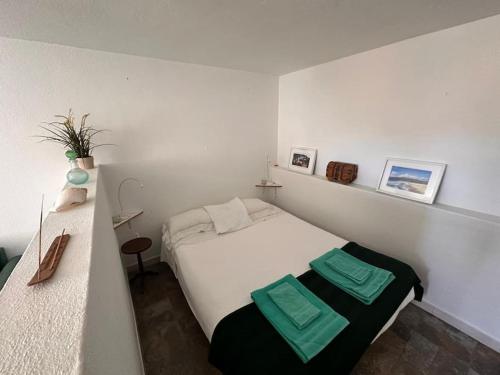 een slaapkamer met een wit bed en 2 groene handdoeken. bij Nice Villa in Cascais, near the center and beaches, but in a very quite neighborhood in Cascais