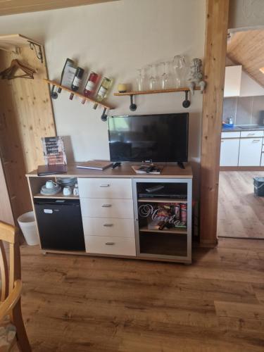 ein Wohnzimmer mit einem TV und einer Küche in der Unterkunft Landhaus Dreibirken in Rothenburg ob der Tauber