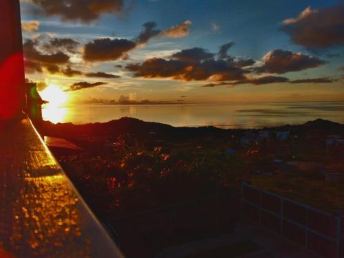 a person standing on a ledge watching the sunset at Residence de la Montagne in Quatre Vents