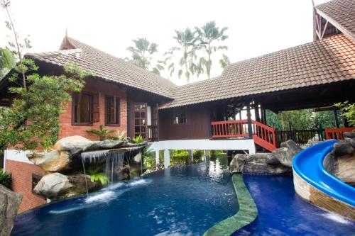 a swimming pool in a house with a waterfall at Carpe Diem Orchard Home in Rawang