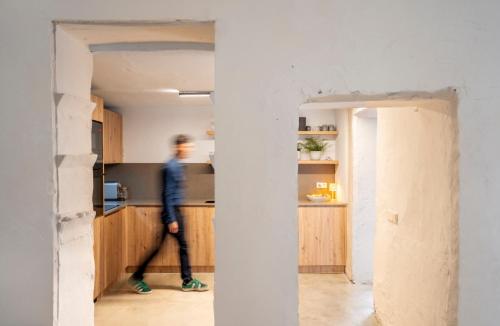 a man walks through the kitchen of a house under construction at Casa cristo 37 navarrés in Navarrés