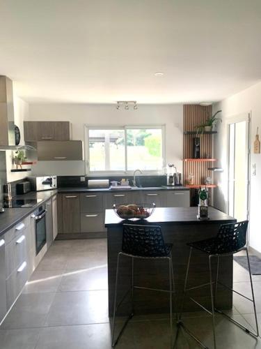 - une cuisine avec une table et deux chaises dans l'établissement Maison climatisée avec grand jardin, piscine privée et Jacuzzi, à Saint-Didier