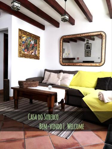 a living room with a couch and a mirror at Casa do Suberco in Nazaré