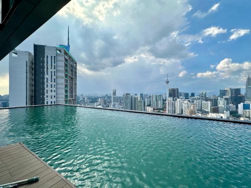 a swimming pool on the roof of a building with a city at Smart Home at Lucentia Residence BBCC Lalaport in Kuala Lumpur