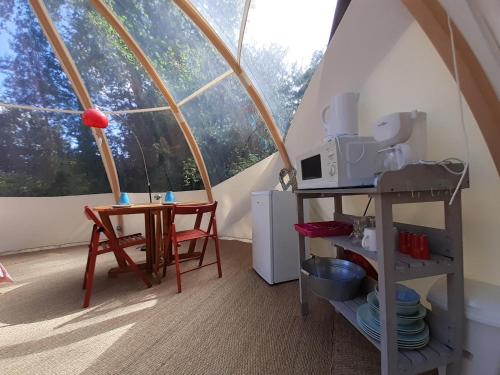 een kamer met een tafel en een magnetron in een tent bij Clos Cacheleux in Miannay