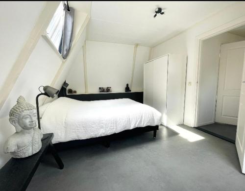 een slaapkamer met een bed met een standbeeld in de hoek bij Volledige bovenwoning binnenstad in Leeuwarden