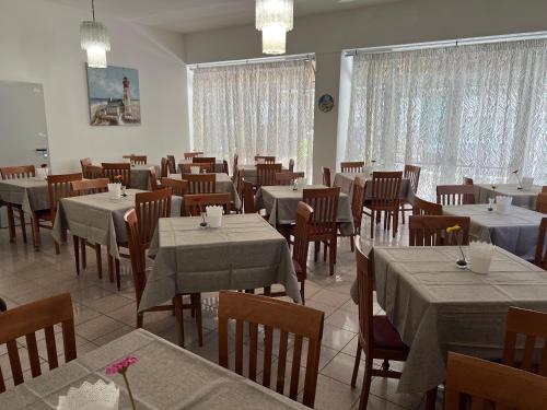 uma sala de jantar cheia de mesas e cadeiras com mesa em Due Gemelle em Rimini