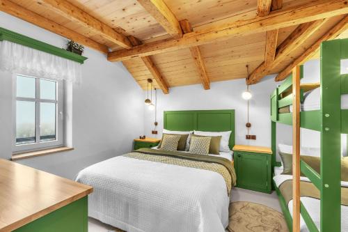 a bedroom with a green bed and a wooden ceiling at Ludvíkova bouda in Janske Lazne