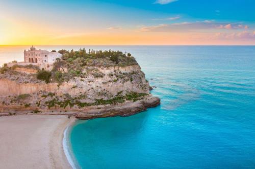 an island in the ocean with a building on it at Greta Apartment Tropea in Tropea