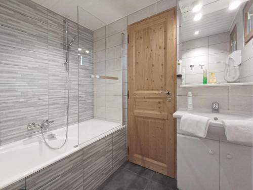 a bathroom with a shower and a tub and a sink at Hôtel du Crêt Rond in Valloire