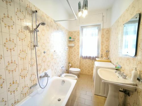 een badkamer met een bad, een toilet en een wastafel bij Bellavista Apartment in Baveno
