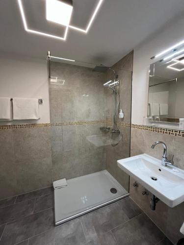 a bathroom with a sink and a shower and a sink at Hotel Landhaus Sternen in Sipplingen
