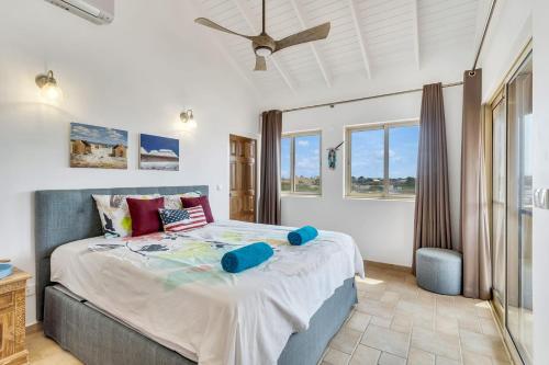 a bedroom with a large bed with a ceiling fan at Casa Chillville in Water Villas Bonaire in Kralendijk