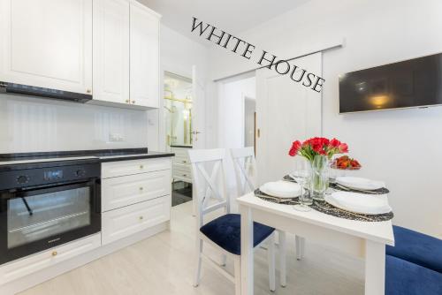 une cuisine avec un panneau blanc de la maison sur le mur dans l'établissement Apartament White House Ustka Granatowy 2B, à Ustka