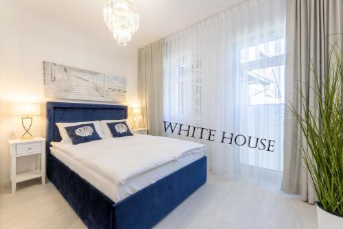 - une chambre avec un lit bleu dans une maison blanche dans l'établissement Apartament White House Ustka Granatowy 2B, à Ustka