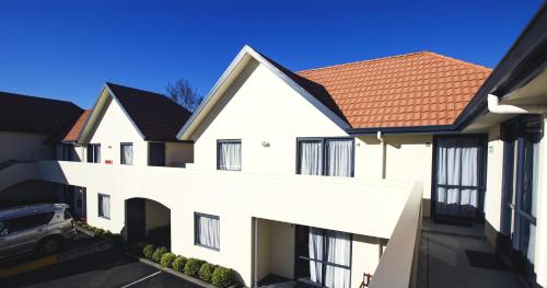 a white building with a red roof at Bella Vista Taupo in Taupo