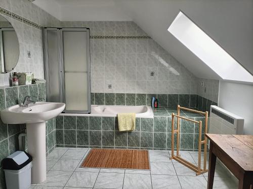 een badkamer met een wastafel en een bad bij Maison de Laurence - La Chaumiére de Mauvrain in La Celle-sur-Nièvre