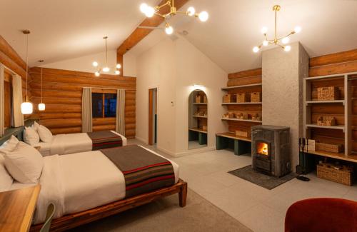 a bedroom with two beds and a fireplace at Bell 2 Lodge in Bell II