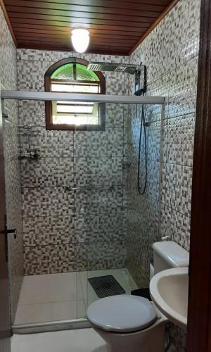 uma casa de banho com um chuveiro, um WC e um lavatório. em Refúgio Hangarana em Angra dos Reis