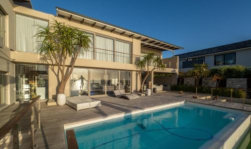 a swimming pool in front of a house at Lavender Dreams - Villa 111 in Hermanus