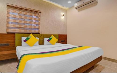 ein Schlafzimmer mit einem großen weißen Bett mit bunten Kissen in der Unterkunft Hotel Abhilasha inn in Pachmarhi