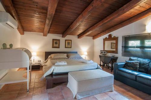 een slaapkamer met een bed en een bank bij villa costanza in Cefalù