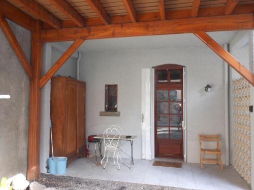 un patio avec une table et une porte en bois dans l'établissement Charmant meublé dans chalet montagnard, à Luchon