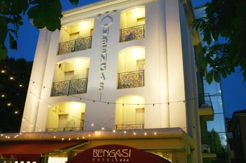 a tall white building with lights on it at hotel bengasi in Rimini