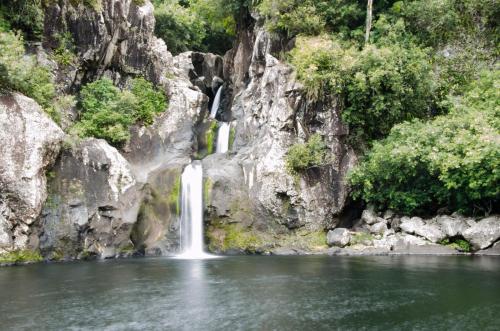 a waterfall in the middle of a body of water at La villa de la Rivière du mât in Saint-André