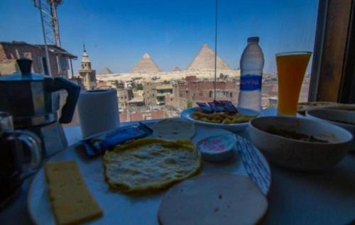 uma mesa com comida e vista para as pirâmides em Pyramids station View no Cairo