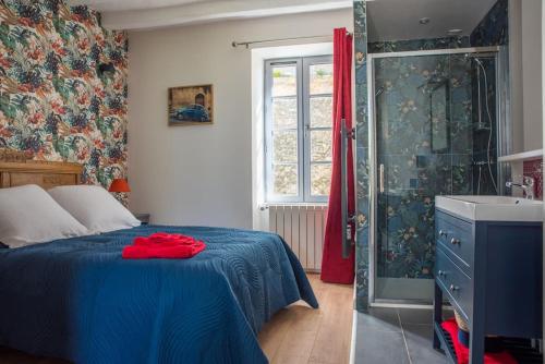 - une chambre avec un lit bleu et une douche dans l'établissement Les Jardins de l'Orangerie, à Durtal