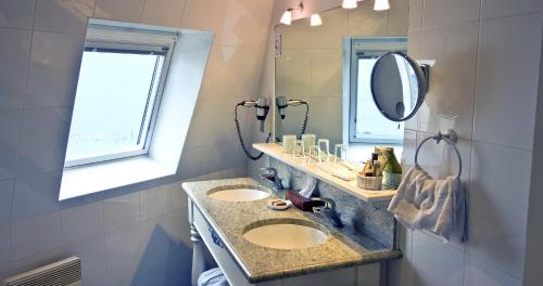 a bathroom with two sinks and a mirror at TI AL LANNEC Hotel - Restaurant & Spa in Trébeurden