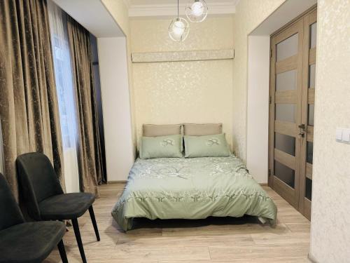 sypialnia z łóżkiem i krzesłem w obiekcie Tbilisi-apartment w mieście Tbilisi City