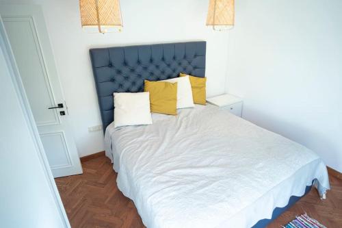 una camera da letto con un grande letto bianco con cuscini gialli di Avantura Avala a Belgrado