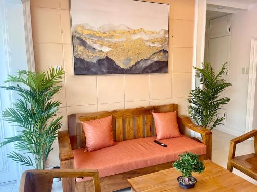 a couch in a living room with a painting on the wall at Explore Iloilo - Accessible Apartment in Iloilo City