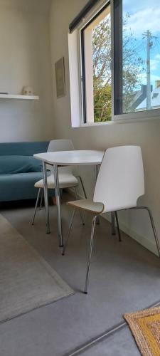 une table et des chaises dans une pièce avec une fenêtre dans l'établissement Studio cosy et calme, à Pont-lʼAbbé