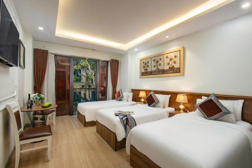 a hotel room with two beds and a television at Tunger Premium Hotel & Travel in Hanoi