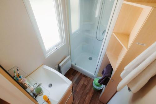 a small bathroom with a shower and a sink at Camping Le Malazéou Wellness Sport Camping in Ax-les-Thermes