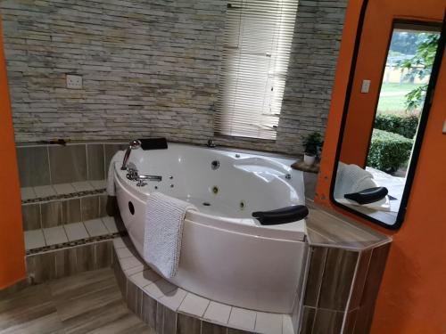 a large white bath tub in a room with a window at Lungakaunakho Country Lodge in Port Edward