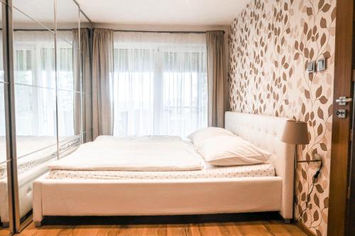 a white bed in a room with a window at Sweet Home in Příchovice