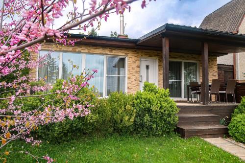 Una casa con un porche y una terraza con flores rosas. en Sweet Home, en Příchovice