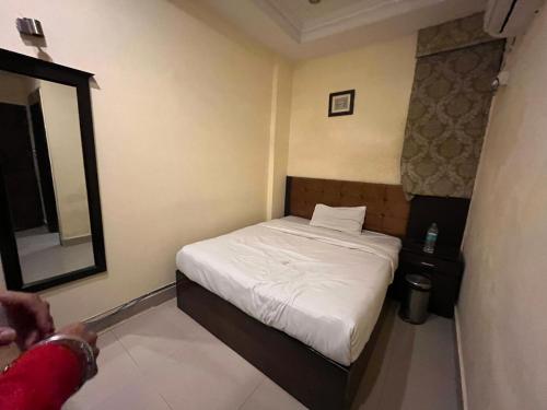 - une petite chambre avec un lit et un miroir dans l'établissement Royal Grand INN, à Amritsar