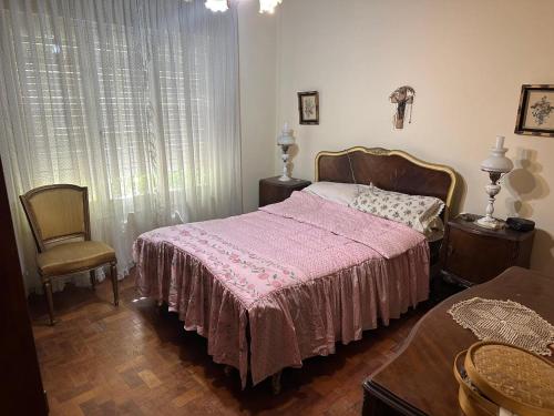 a bedroom with a pink bed and a chair at CASA PATRICIAS in Godoy Cruz