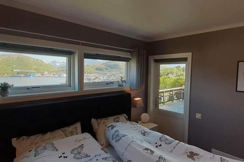 a bedroom with two beds and two windows at Nice house with a great view! in Skjervøy