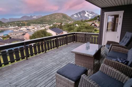 a deck with chairs and a table on a house at Nice house with a great view! in Skjervøy