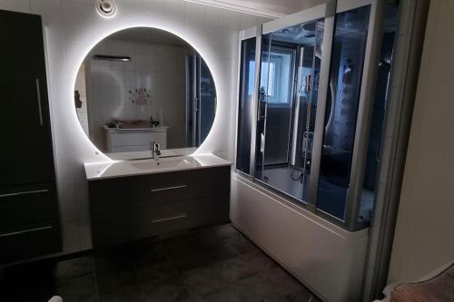 a bathroom with a sink and a large mirror at Nice house with a great view! in Skjervøy