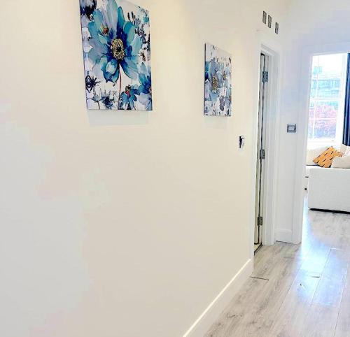 een witte woonkamer met twee schilderijen aan de muur bij Harrow Apartments in Londen